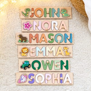 May include: Wooden name puzzles with colorful letters and animal-themed illustrations. Each puzzle spells out a name: John, Nora, Mason, Emma, Owen, and Sophia. The puzzles are on a light-colored surface.