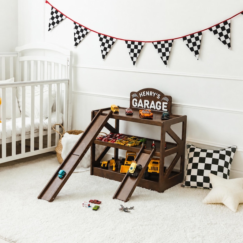 May include: A dark brown wooden toy garage with three levels, two attached ramps, and a sign reading "HENRY'S GARAGE" with checkered flag icons. The structure holds various small toy vehicles, including yellow construction trucks and colorful cars.
