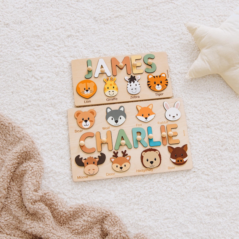 Personalized wooden name puzzle for kids with animal shapes, featuring names “James” and “Charlie.” Montessori toy made of natural wood with colorful letters and cute animals like lion, giraffe, zebra, tiger, bear, fox, rabbit, moose, deer, hedgehog, and boar. Wide variety of designs, colors, and animal sets available. Educational toddler puzzle for learning names and fine motor skills, perfect baby gift or nursery decor, displayed on a soft neutral rug.