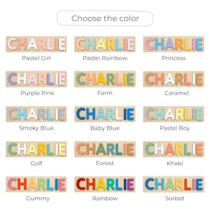 Puede incluir: Rompecabezas de madera con el nombre "CHARLIE" en varios esquemas de color. Cada rompecabezas tiene una base de madera con letras individuales. Los esquemas de color incluyen pastel, arco&iacute;ris y azul ahumado. La imagen muestra diferentes opciones.