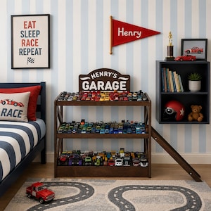 May include: A dark brown wooden three-tier display shelf with a sign reading Henry's Garage, filled with numerous small toy cars. The unit features a side ramp and is positioned in a room with a bed, a wall-mounted shelf, and a race track rug.
