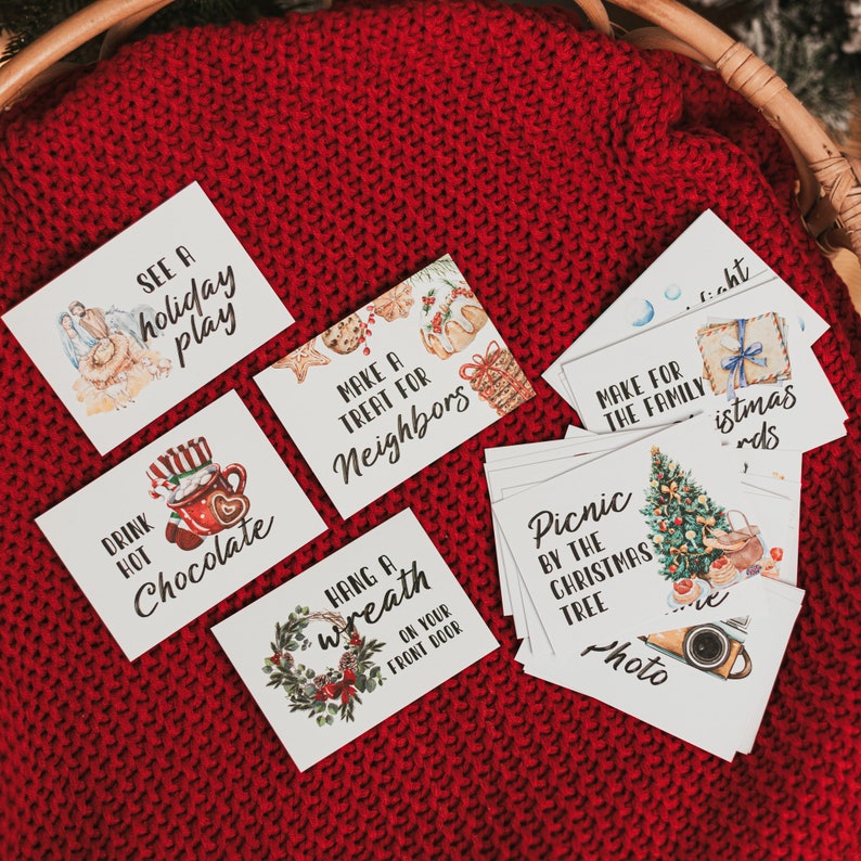 May include: A set of 10 Christmas activity cards with watercolor illustrations. The cards feature activities like seeing a holiday play, drinking hot chocolate, making a treat for neighbors, hanging a wreath, having a picnic by the Christmas tree, and making a family Christmas cards.