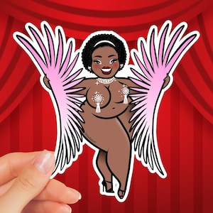 Op de afbeelding: Een sticker met een cartoonillustratie van een persoon met een bruine huid, met een witte hoofdband, een parelketting en tepelhoezen. De persoon houdt roze en witte gevederde vleugels vast. De achtergrond is een rood gordijn.