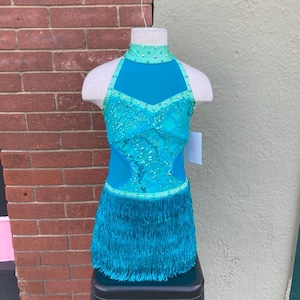 May include: A turquoise dance costume with a halter neckline, a sheer bodice with sequins, and a fringe skirt.