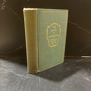 May include: A vintage book titled "The Hymn as Literature" by Jeremiah Bascom Reeves. The book has a green cover with gold lettering and a decorative frame. The spine is a lighter green color.