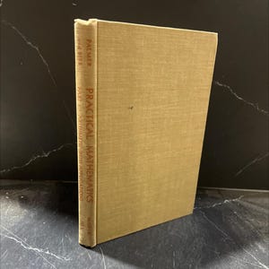 May include: A tan-colored hardcover book titled "Practical Mathematics" with the authors Palmer and Bibb. The book's spine displays the title in a vertical format with red lettering. The book is in good condition.