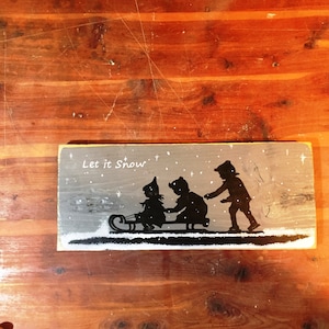 Kerst houten bord.  Kinderen op een rodelbaanslee. Boerderij op het platteland, Rustiek wandbord, hangend palletbord