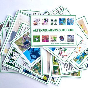 Könnte beinhalten: Ein Stapel Karten mit grünen Rändern und Bildern von Outdoor-Kunstprojekten. Die oberste Karte trägt den Titel "Art Experiments Outdoors" und den Text "Mary Jackson und Alison Jackson-Bass".