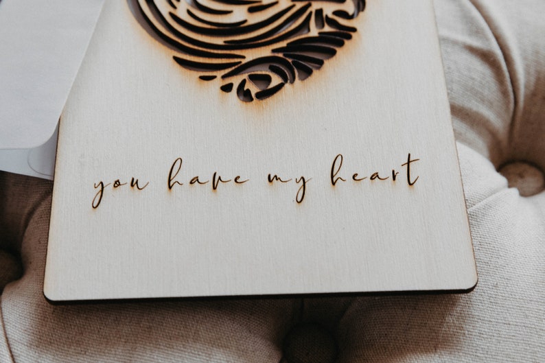 Puede incluir: Una tarjeta de madera con un dise&ntilde;o de coraz&oacute;n cortado con l&aacute;ser y el texto "you have my heart" escrito en cursiva.