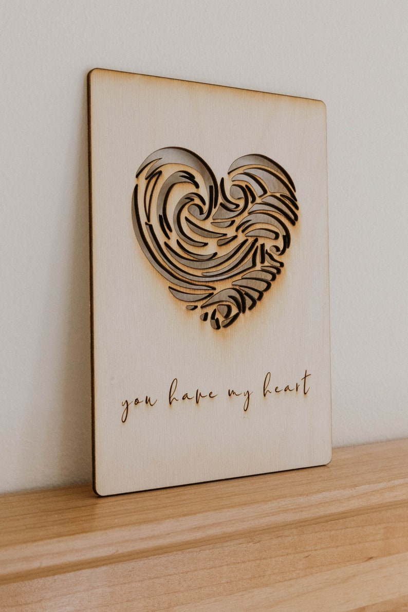 Puede incluir: Una tarjeta de madera con un dise&ntilde;o de coraz&oacute;n recortado y el texto "you have my heart".