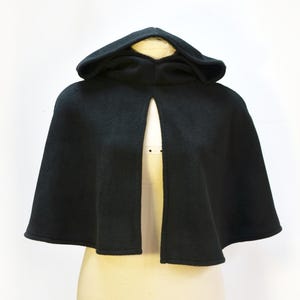 Mannequin wearing black fleece cape with a hood
