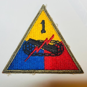 May include: A triangular patch with a yellow background, a red and blue section, and a black and white symbol. The number "1" is in the yellow section. The symbol is a lightning bolt and a chain link.