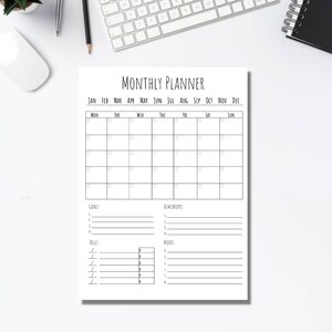 以下が含まれることがあります： 白を基調とした、黒のミニマルデザインのマンスリープランナー。カレンダーグリッド、目標、リマインダー、請求書、メモのセクションが含まれています。「MONTHLY PLANNER」の文字が上部にあります。