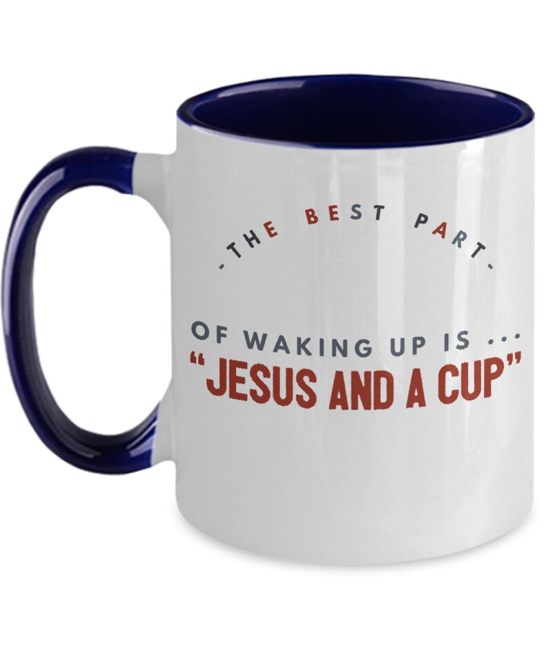 May include: White ceramic coffee mug with a blue rim and handle. The mug has a saying on it that reads "The best part of waking up is... "Jesus and a cup"