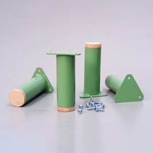 May include: Four green metal furniture legs with a wood top and a triangular base. The legs are accompanied by a pile of screws.