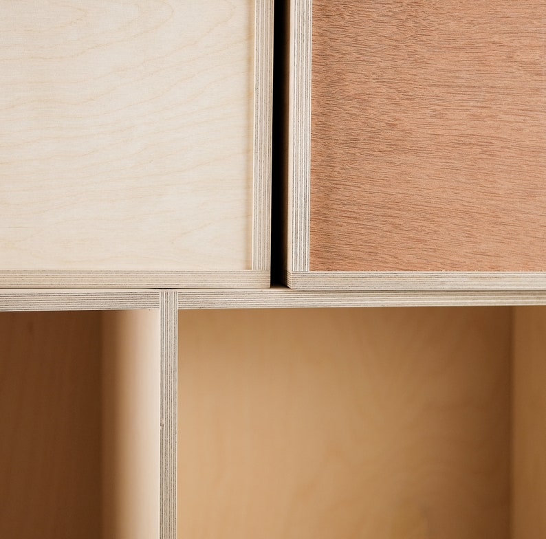 May include: Close-up of a wooden cabinet with a light brown, medium brown, and dark brown finish. The cabinet has a simple design with clean lines and a modern aesthetic.