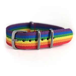 Op de afbeelding: Een regenboog gestreepte horlogeband met een roestvrijstalen gesp en lussen. De band heeft een levendig spectrum aan kleuren, waaronder rood, oranje, geel, groen, blauw en paars. De horlogeband is ontworpen voor een standaard horloge.