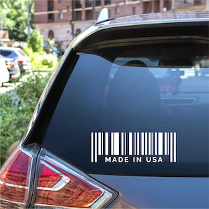 Puede incluir: Una pegatina de vinilo blanca con un código de barras y el texto "MADE IN USA" en un coche azul.