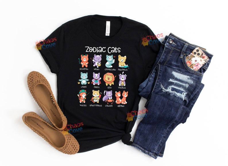 May include: Black t-shirt with a graphic of zodiac signs represented by cats. The text "Zodiac Cats" is printed in white at the top of the graphic.