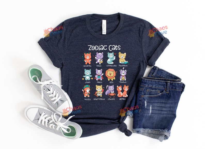 May include: A navy blue t-shirt with the text "Zodiac Cats" and a graphic of 12 cats representing the zodiac signs. Each cat is wearing a different costume and has a different color scheme.