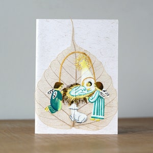 Christmas Card Hand painted on Bodhi Leaf Handmade Paper. Baby Jesus in a crib with Angels around. Hand made paper.