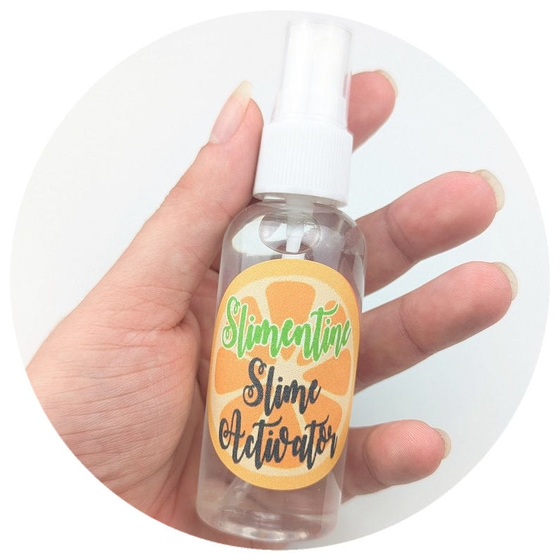 K&ouml;nnte beinhalten: Eine durchsichtige Plastikflasche mit einer wei&szlig;en Spr&uuml;hd&uuml;se und einem Etikett mit der Aufschrift "Slicentine Slime Activator". Das Etikett ist orange mit einer gr&uuml;nen Orangenscheibe.