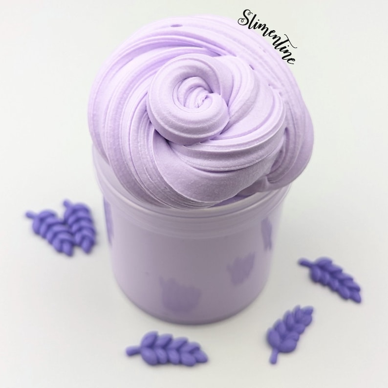 May include: A purple slime in a clear jar with a white background. There are four purple leaf-shaped decorations around the jar.