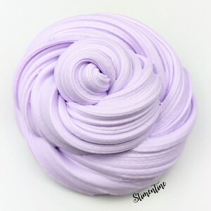 May include: A close-up of a light purple slime, a popular sensory toy, with a smooth, creamy texture. The slime is in a swirl pattern, creating a visually appealing and satisfying image.