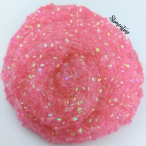 May include: Pink slime with iridescent glitter. The slime is in a swirl pattern and has a glossy finish.