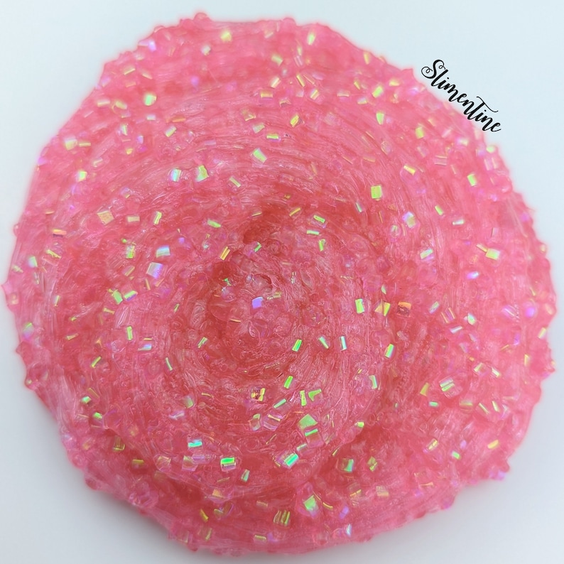May include: Pink slime with iridescent glitter. The slime is in a swirl pattern and has a glossy finish.
