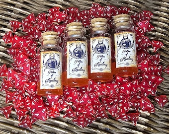 May include: Four small glass bottles with cork stoppers filled with a red liquid. Each bottle has a label that reads "Potion of Healing". The bottles are surrounded by red four-sided dice.
