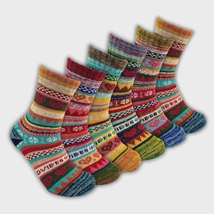 May include: Six pairs of patterned socks in a diagonal arrangement. Each sock displays a unique mix of stripes, geometric patterns, and heart designs in red, blue, yellow, and green. The socks are made of a thick, warm material.