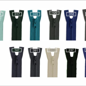 May include: A collection of eleven plastic zippers in various colors, including light green, dark green, teal, grey, blue, black, navy, and beige. Each zipper features a matching pull tab and a rectangular label with a numerical code: 004, 017, 020, 120, 058, 080, 147, 391, 235, 237, and 266.