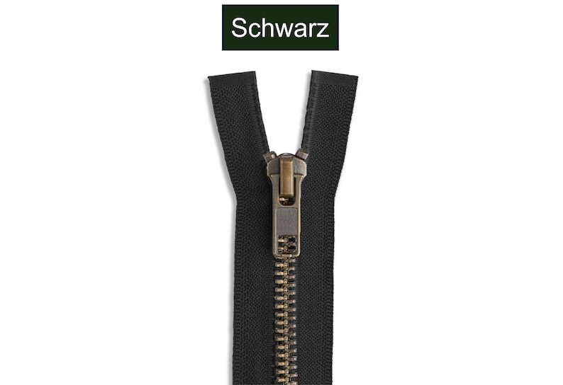 K&ouml;nnte beinhalten: Ein schwarzer Rei&szlig;verschluss mit metallisch bronzefarbenen Z&auml;hnen und einem passenden bronzefarbenen Schieber. Das obere Ende des Rei&szlig;verschlussbandes ist geteilt. &Uuml;ber dem Rei&szlig;verschluss befindet sich ein Etikett mit dem Wort Schwarz.