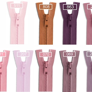 May include: A collection of ten plastic zippers in various shades of pink, purple, and brown, arranged in two rows. Each zipper features a matching pull tab and a rectangular label with a specific color code number: 511, 808, 863, 214, 811, 207, 070, 069, and 212.