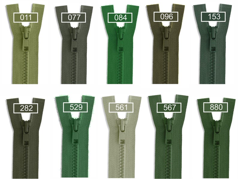 May include: A collection of ten plastic zippers in various shades of green, arranged in two rows. Each zipper features a matching pull tab and is labeled with a white rectangular box containing the specific color code numbers 011, 077, 084, 096, 153, 282, 529, 561, 567, and 880.