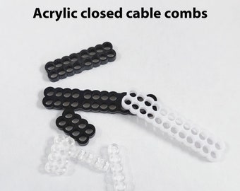 May include: Black and white acrylic closed cable combs. The combs are made of plastic and have a honeycomb pattern.