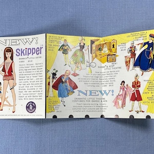 May include: A vintage Mattel toy advertisement brochure featuring the Skipper doll and various Barbie and Ken costume sets. The paper displays illustrations of dolls in theatrical outfits, including Cinderella, King Arthur, and Arabian Nights themes.