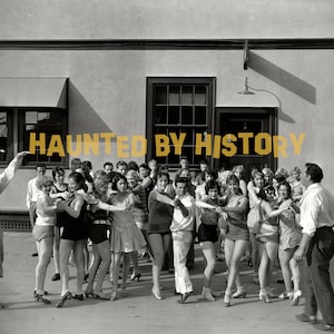 Może przedstawiać: Czarno-białe zdjęcie grupy ludzi stojących przed budynkiem. Tekst "HAUNTED BY HISTORY" jest napisany u góry obrazu.