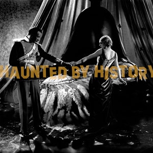 May include: A black and white photograph of a couple in a bedroom. The man is wearing a military uniform and the woman is wearing a long dress. The text "HAUNTED BY HISTORY" is superimposed on the image.