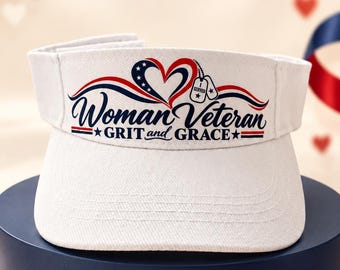 May include: A white visor featuring a graphic of a heart with stars and stripes, two dog tags, and the text "Woman Veteran GRIT and GRACE" in navy blue and red. The design includes a star on each side of the text and patriotic color accents.