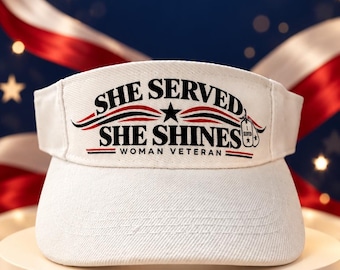 May include: A white visor featuring the black text SHE SERVED SHE SHINES WOMAN VETERAN. The design includes a black star, red and blue wavy lines, and a small graphic of a military dog tag with the word SERVED printed on the tag.