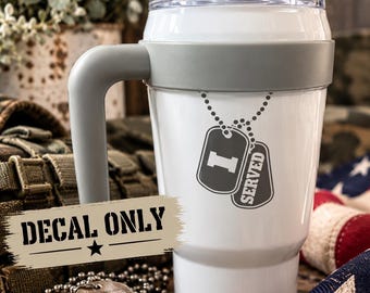 May include: A white tumbler with a gray handle and lid, featuring a dark gray decal of two military-style dog tags on a chain with the text I SERVED. A rectangular beige label with the black text DECAL ONLY is positioned over the tumbler.