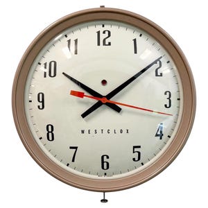 May include: A circular, vintage Westclox wall clock with a cream face and a light brown metal frame. It has black numerals, black hands, and a red second hand. The text "WESTCLOX" is printed on the face. Made in Canada.