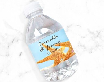 May include: A clear plastic water bottle with a blue and white label featuring a starfish and the text "Carmella & Jeremy 6.18.26".