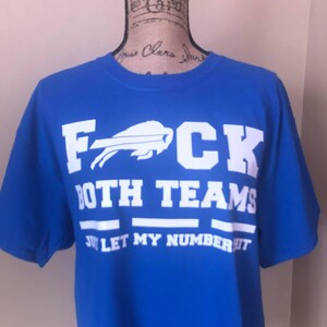 Puede incluir: Camiseta azul real con texto blanco que dice "F**K BOTH TEAMS" y "JUST LET MY NUMBER HIT". El logo de los Buffalo Bills está encima de la palabra "CK".