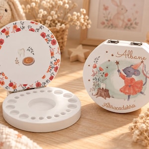 Peut inclure: Une boîte à dents ronde en bois blanc avec un couvercle à charnière. L'extérieur présente une illustration de souris, le prénom Albane et le texte Abracadabra. L'intérieur du couvercle a une bordure florale et une icône de dent.