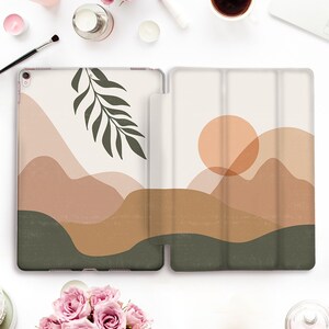 Pode incluir: Uma capa branca com um design de paisagem em cores castanho, verde e laranja. O design inclui um sol, montanhas e um ramo de folhas.