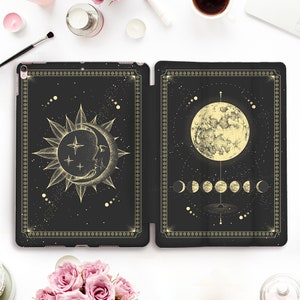 Könnte beinhalten: Eine schwarze iPad-Hülle mit einem goldenen Design von Sonne und Mond. Die Sonne ist mit einem Halbmond darin dargestellt. Der Mond ist mit einem Vollmond und den Mondphasen dargestellt.