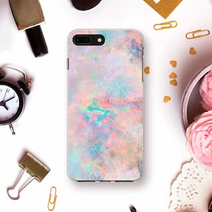 May include: A pink, blue and green opal-patterned phone case for an iPhone.